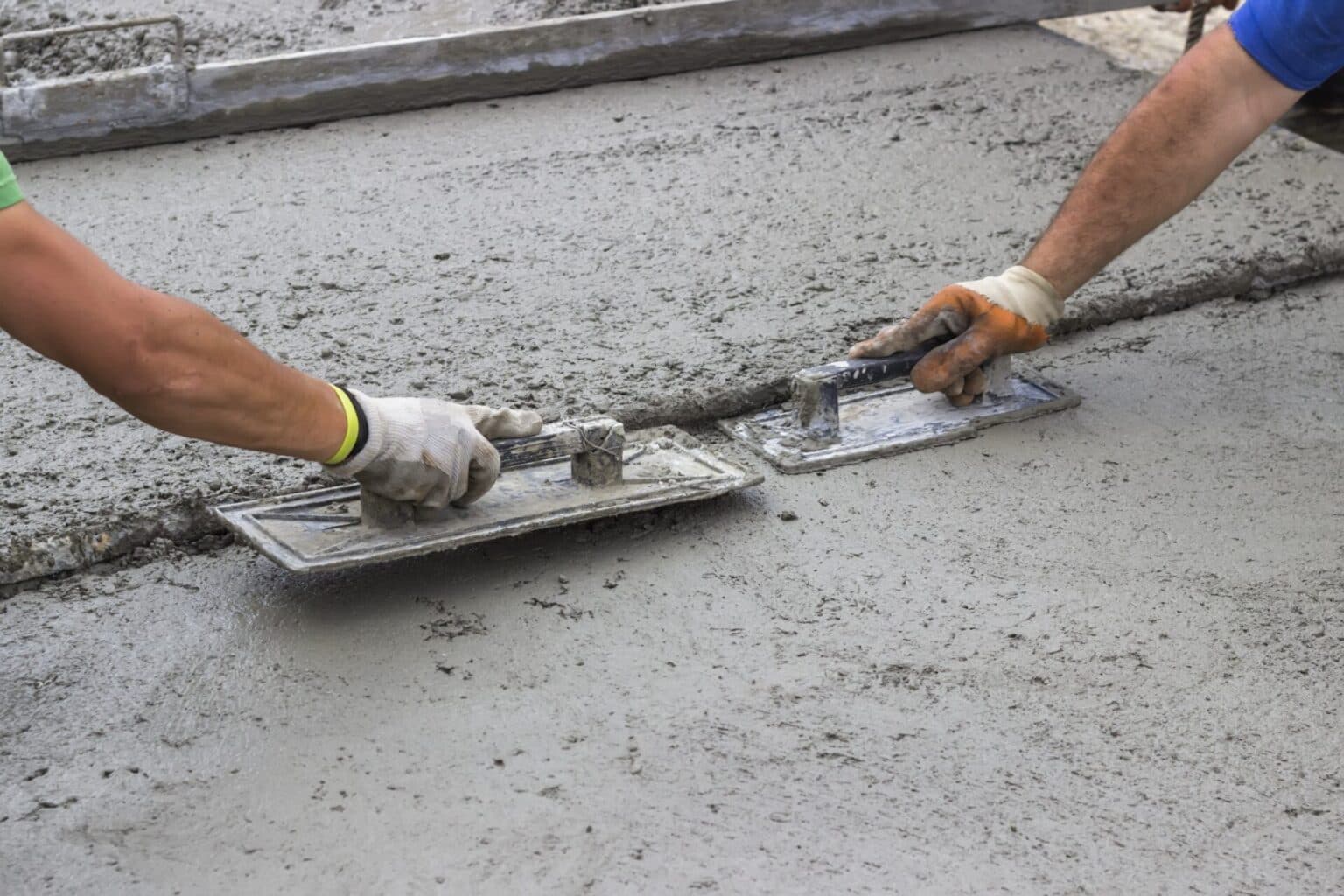 Worker leveling a concrete surface on a driveway